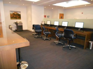 A very large business center with computers and laptop stations.