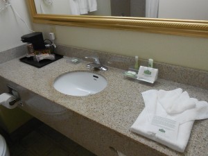 The bathroom sink/vanity, including the standard amenities (Pantene Shampoo & Conditioner and Vaseline Lotion).