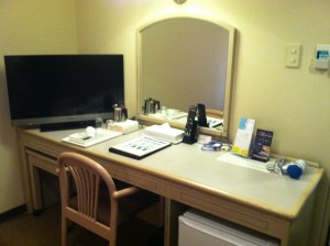 a desk with a mirror and a television