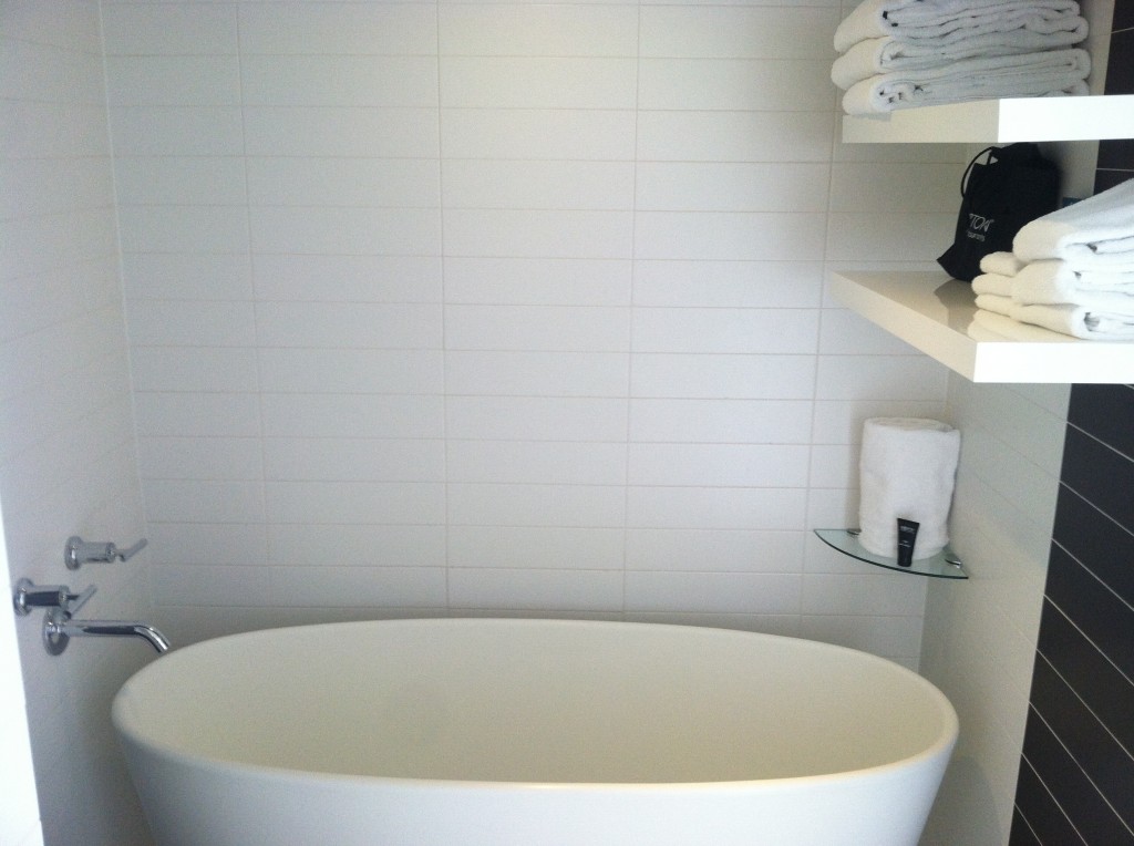 a white bathroom with a tub and towels